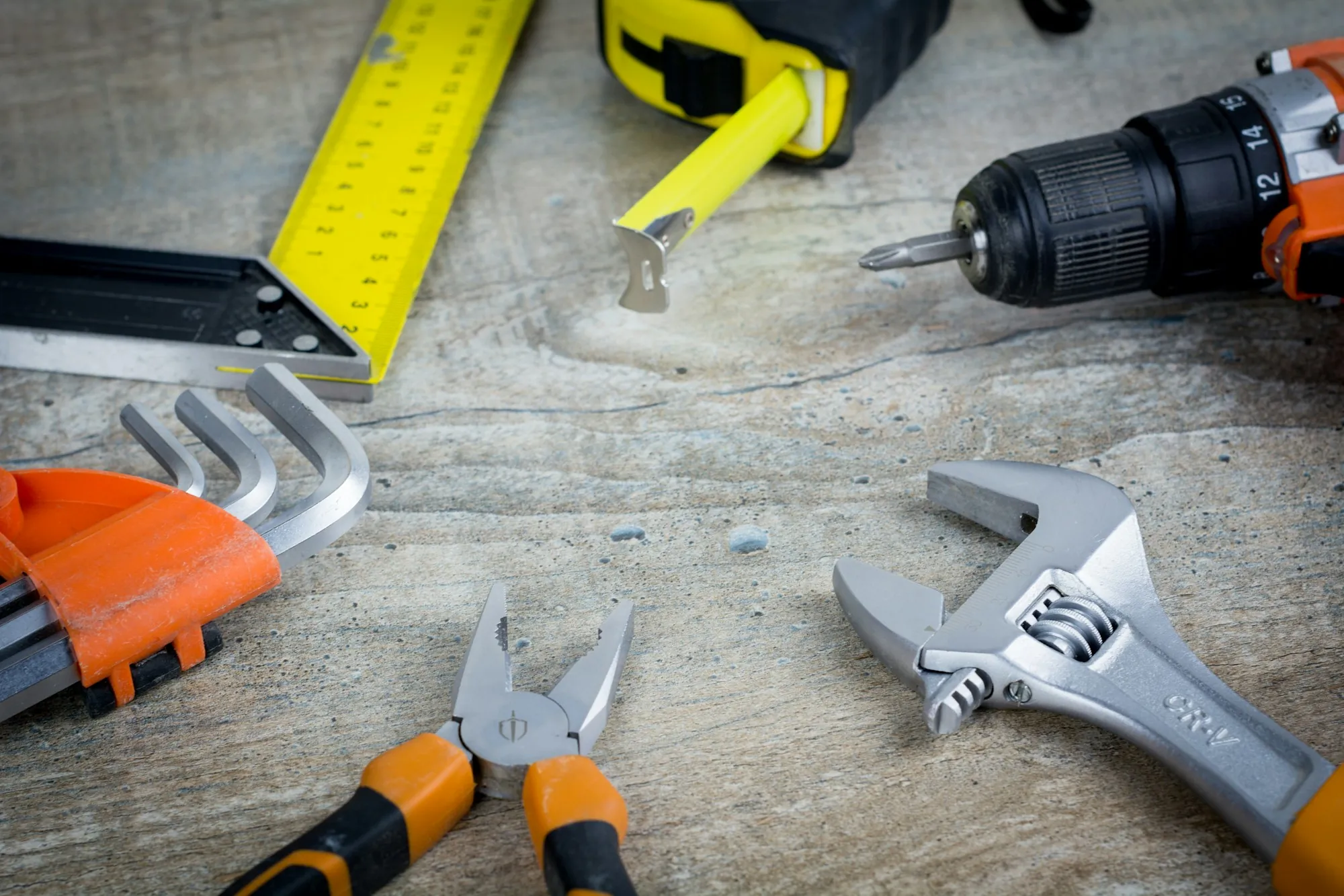 Drill, wrench, pliers and hex keys on a work surface