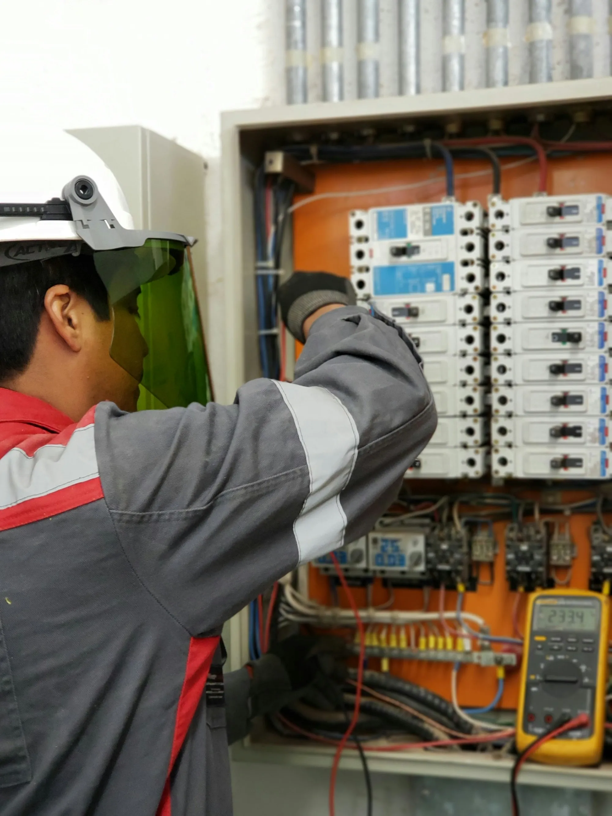 Technician adjusting components in an electrical control panel